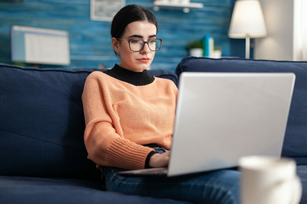 College student with glasses checking email on laptop computer ecommerce website