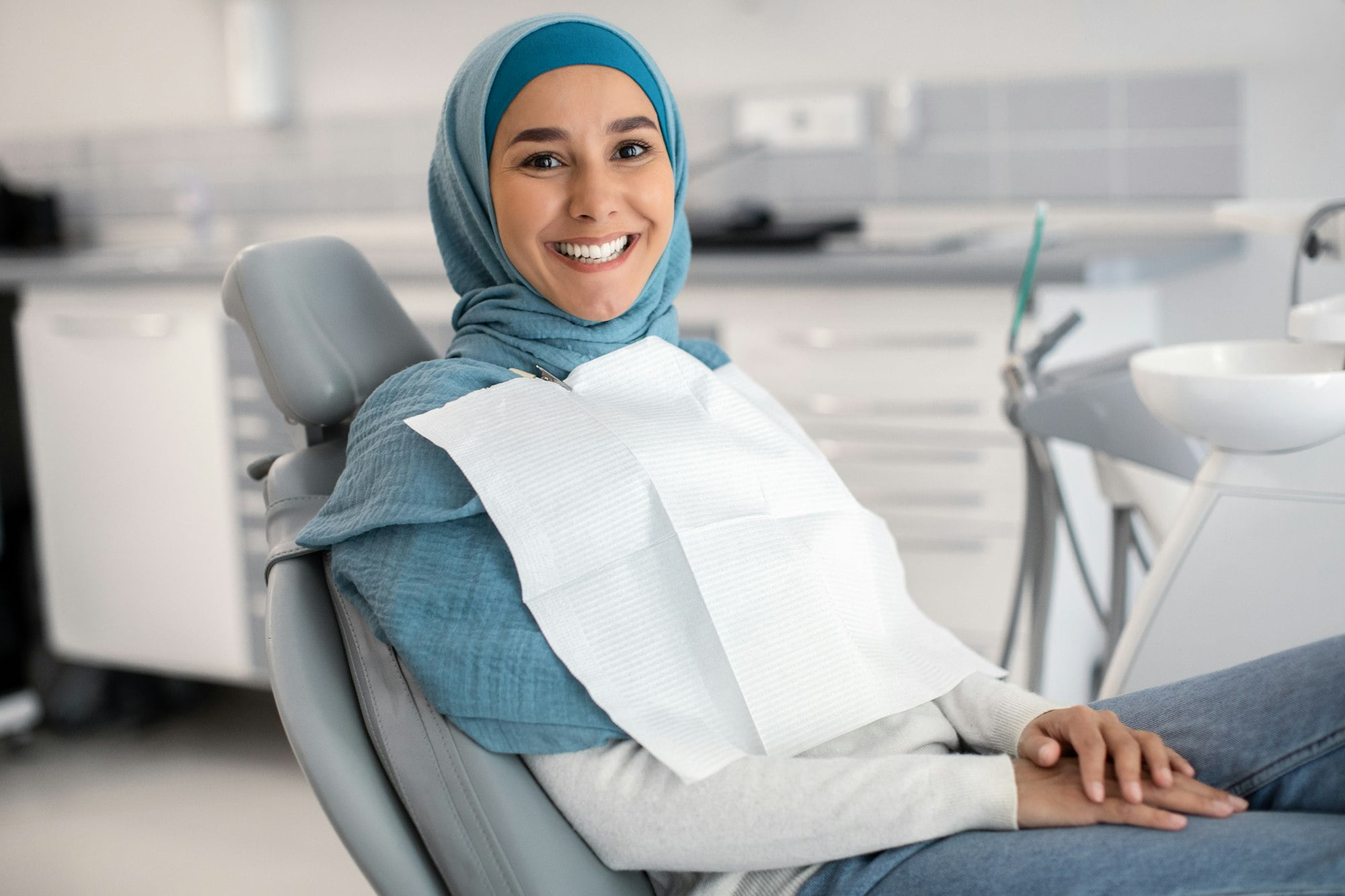 Happy Islamic Lady In Hijab Sitting In Chair At Dental Clinic