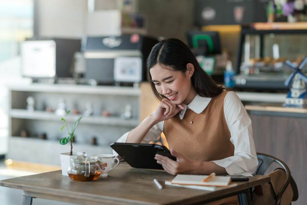 Image of Asian businesswoman enjoy working life using a tablet at the café.