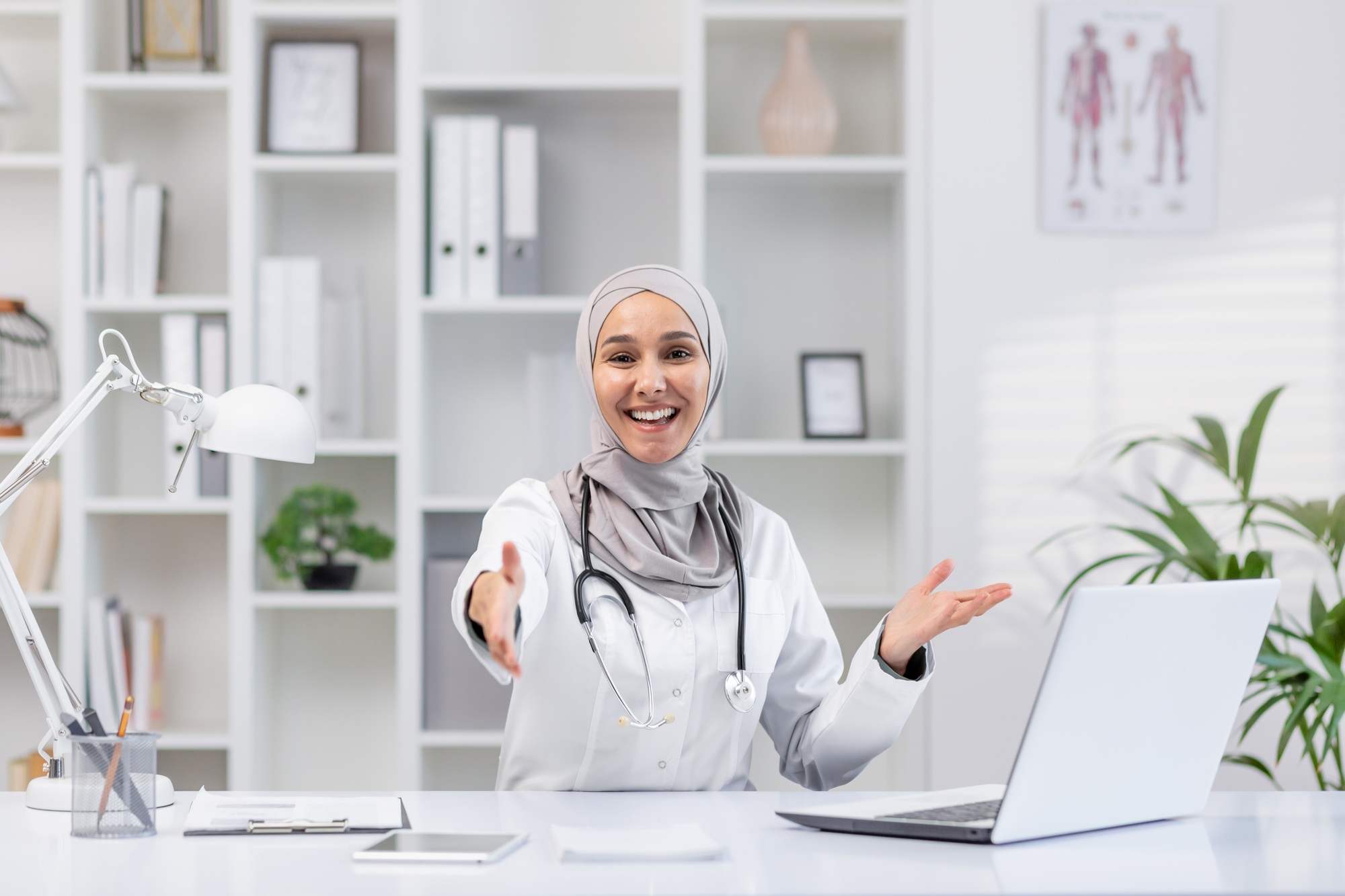 Friendly female doctor in hijab extends a handshake